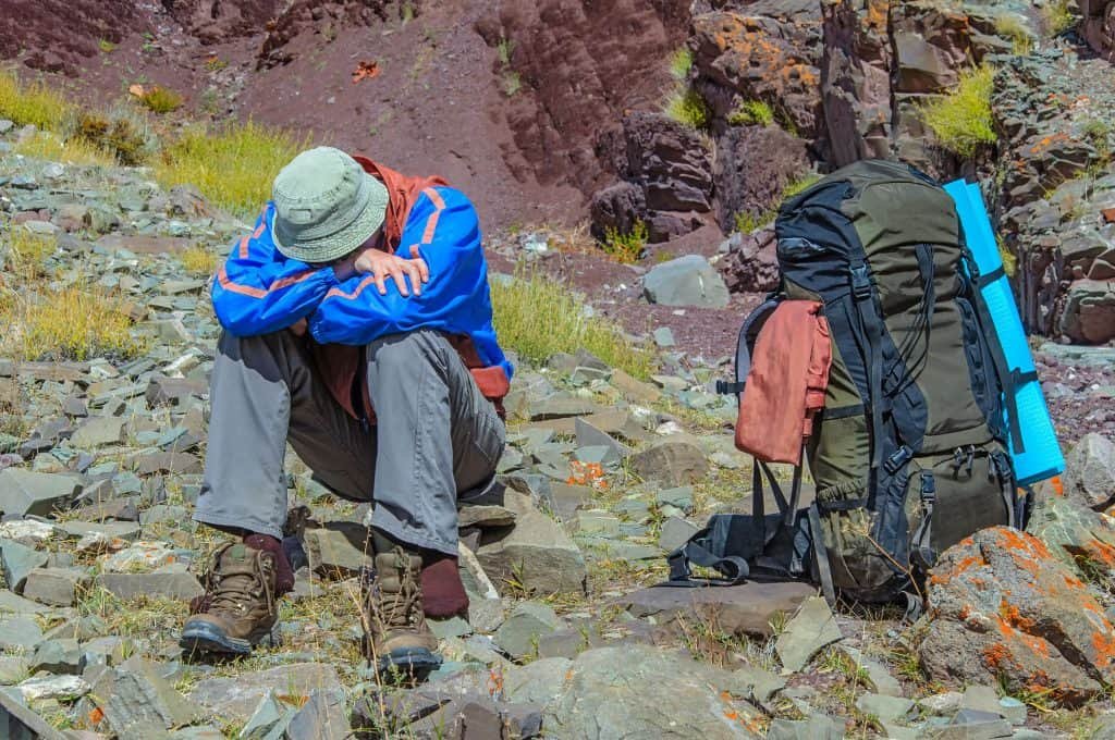 Homem descansa em local de alta altitude porque o corpo humano reage com essa condição